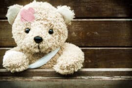 Teddy,Bear,With,Bandages,And,Broken,Hand,On,Wood,Background,copy