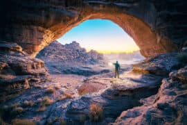 A,Man,Standing,In,A,Cave,At,Sunset,Natural,Rock
