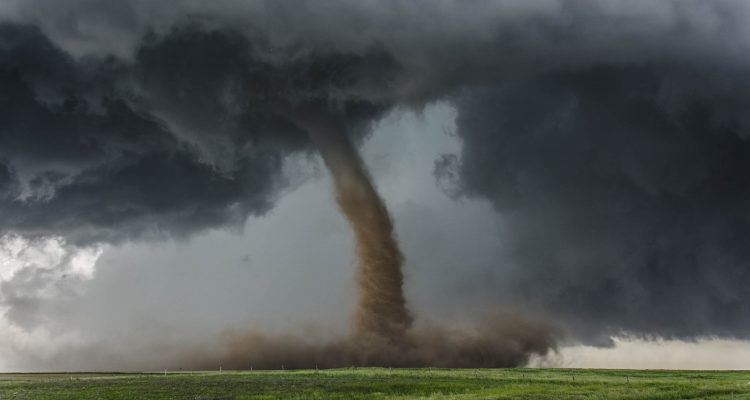 A tornado over a green field