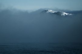 Mountain peak from clouds at Arctic Ocean