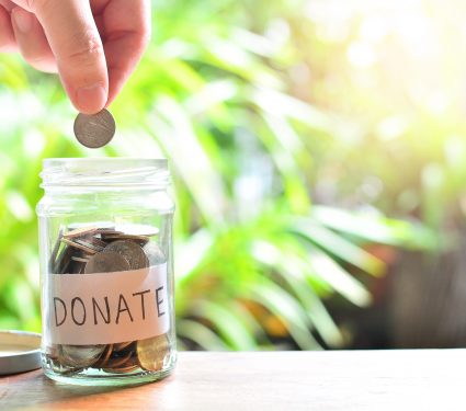 Putting,Coins,On,Donate,Glass,Bottle,For,Concept,Charity,And