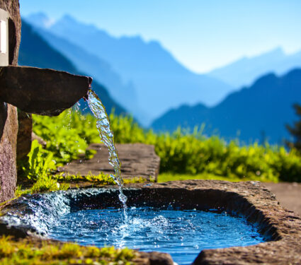 Water,Spring,On,Alps,Mountains,Background.