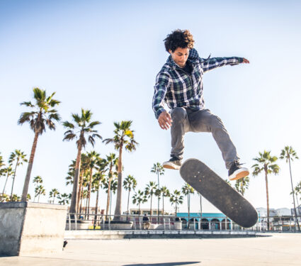 Cool,Skateboarder,Outdoors,-,Afroamerican,Guy,Jumping,With,His,Skate