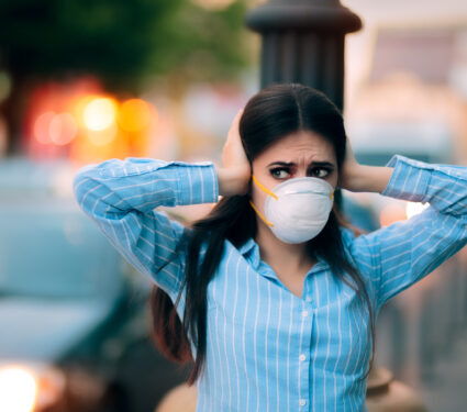 Girl,With,Mask,Covering,Her,Ears,Because,Of,Noise,Pollution