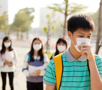 Teenagers,Student,Wearing,Mouth,Mask,Against,Smog,In,City