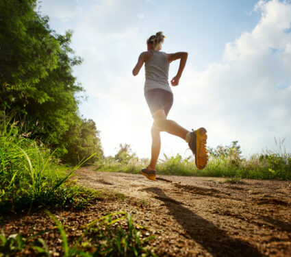 Young,Lady,Running,On,A,Rural,Road,During,Sunset