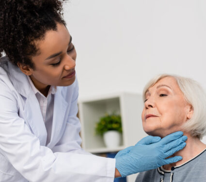 African,American,Docktor,In,While,Coat,Checking,Neck,Of,Elderly
