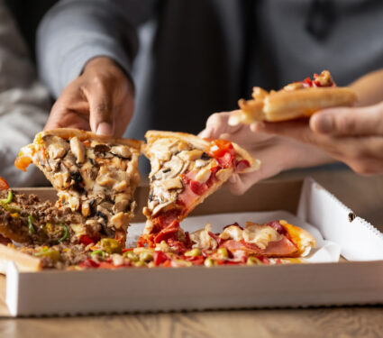 Close,Up,Of,Multiethnic,Young,People,Gather,In,Pizzeria,Together