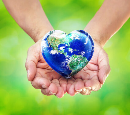Earth,Heart,In,Hands,On,Green,Blurred,Nature,Background,,World