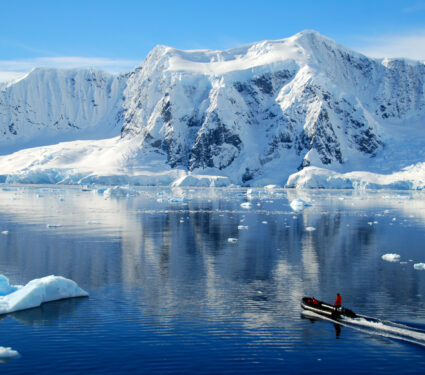 Boat,Dwarfed,By,Antarctic,Mountains