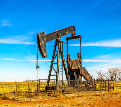 Large,Old,Rusty,Oil,Well,Pump,Jack,Surrounded,By,Cattle
