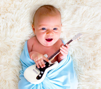 Newborn,Baby,Boy,,Wrapped,In,Blue,Scarf,,Holding,A,Little