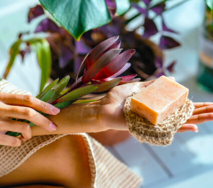 Woman,Hands,Holding,Flower,And,Organic,Soap,And,Jute,Washcloth