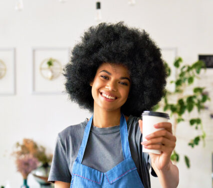 Happy,African,American,Young,Woman,With,Afro,Hair,Modern,Cafe