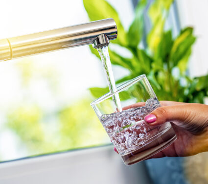 Woman,Hand,Holds,A,Glass,To,Filing,It,With,Water