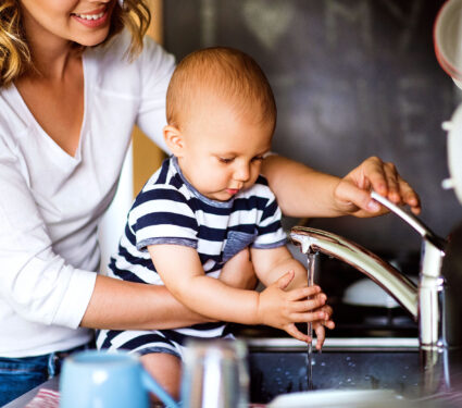 Young,Mother,With,A,Baby,Boy,Doing,Housework.