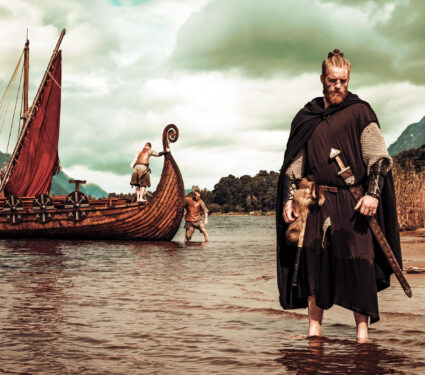 Viking,Warrior,With,Sword,Standing,Near,Drakkar,On,The,Seashore.