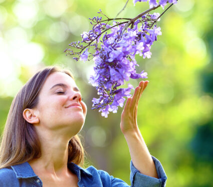 Candid,Woman,Smelling,Flowers,Standing,In,A,Park