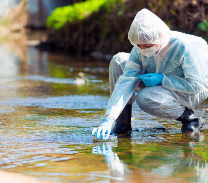 Scientist,Researcher,In,Protective,Suit,Takes,Water,For,Analysis,From