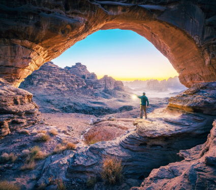 A,Man,Standing,In,A,Cave,At,Sunset,Natural,Rock
