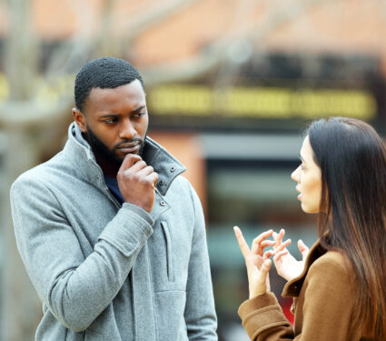 Suspicious,Man,Listening,A,Woman,Talking,In,Winter,In,The