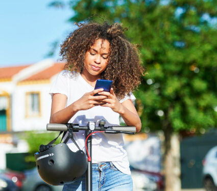 Woman,Using,Smart,Phone,While,Standing,With,Electric,Push,Scooter