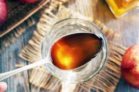 Apple,Cider,Vinegar,On,A,Metal,Spoon,Above,A,Glass