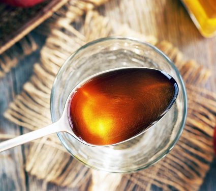 Apple,Cider,Vinegar,On,A,Metal,Spoon,Above,A,Glass