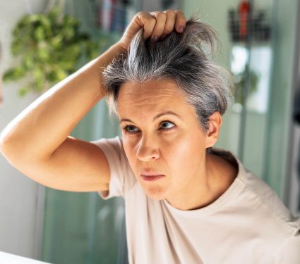 Gray-haired,Mature,Middle-aged,Woman,Looks,At,Herself,In,The,Bathroom